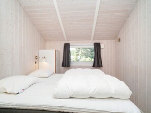 A bedroom with a single bed, a nightstand, a lamp, and a window with curtains. - 7 Person Holiday Home in Graested (Gilleleje)
