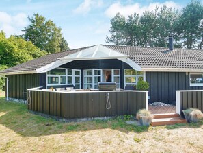 A house with a covered patio, a barbecue grill, and a small garden area. - 7 Person Holiday Home in Graested (Gilleleje)