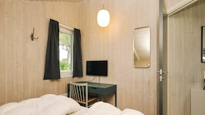 A bedroom with a bed, a desk, a television, and a window with curtains. - 7 Person Holiday Home in Graested (Gilleleje)