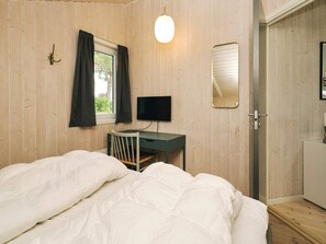 A bedroom with a bed, a desk, a television, and a window with curtains. - 7 Person Holiday Home in Graested (Gilleleje)