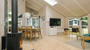 A spacious living area with a large TV, wooden furniture, and a fireplace. - 7 Person Holiday Home in Graested (Gilleleje)
