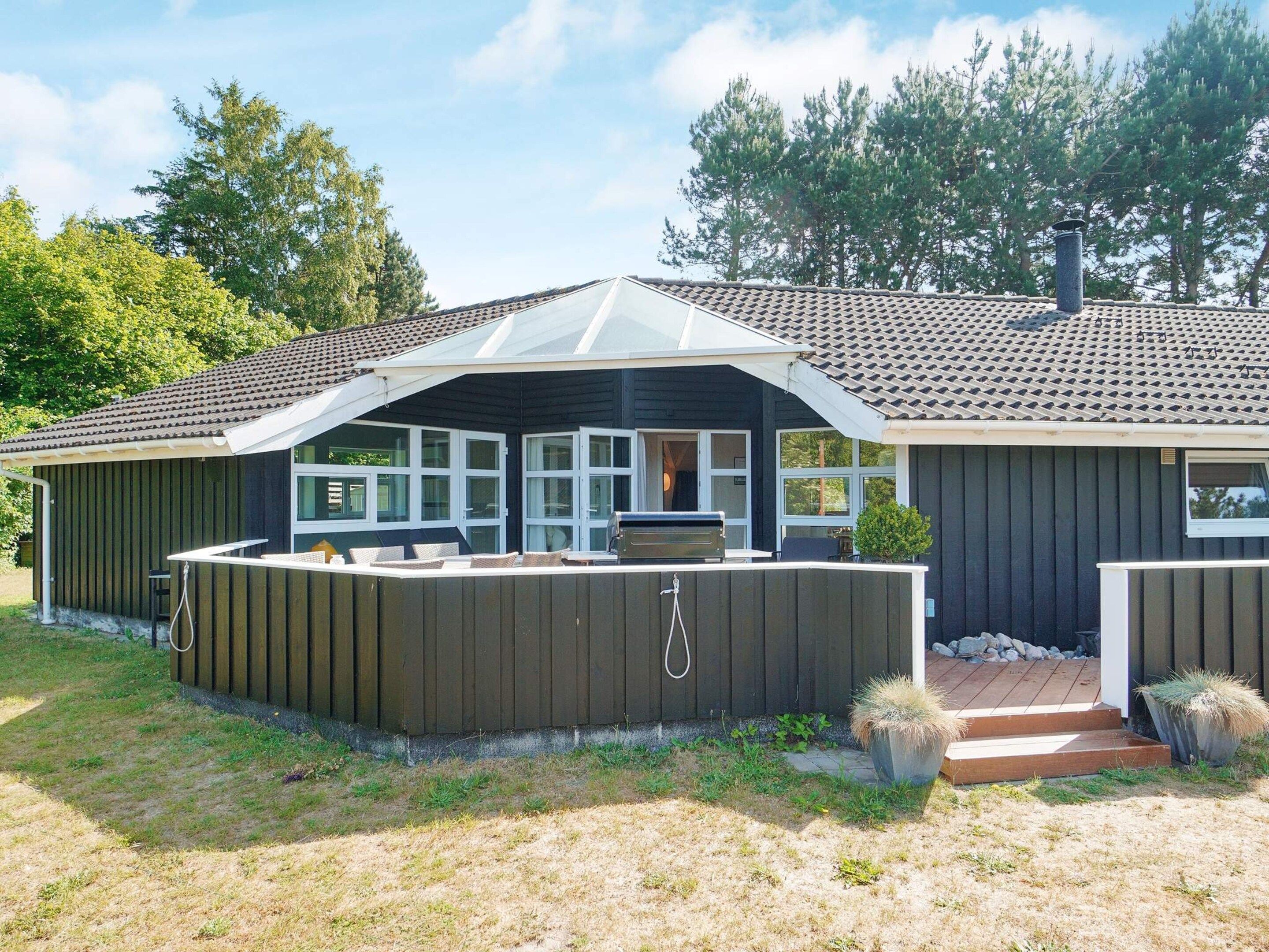 A house with a covered patio, a barbecue area, and a small deck.