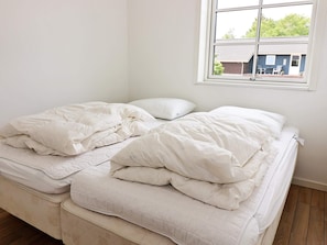 A bed with white bedding in a room with a window. - 8 Person Holiday Home in Hadsund (Hadsund)