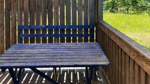 A wooden bench with a metal frame, positioned on a wooden deck with vertical slats. - 4 Person Holiday Home in Vetlanda (Vetlanda)