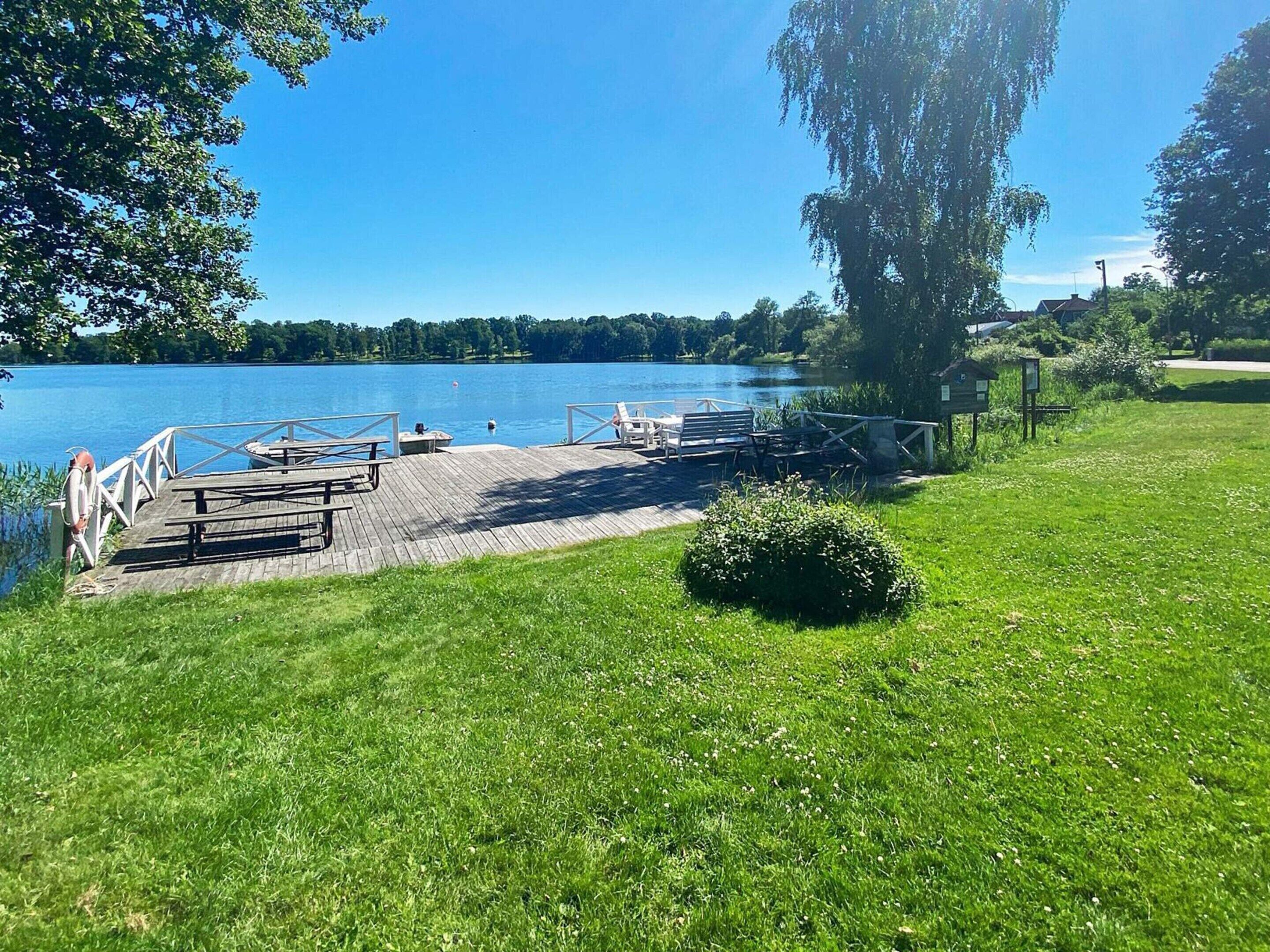 Un parc au bord du lac, doté d’une jetée en bois, de tables de pique-nique et de bancs.