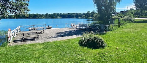 Un parc au bord du lac, doté d’une jetée en bois, de tables de pique-nique et de bancs.