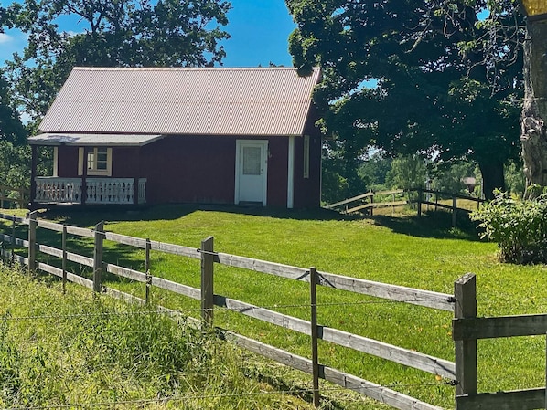 A red building with a white door and a porch with white railings.