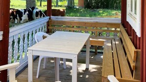 A wooden deck with a white table and benches, surrounded by a white picket fence. - 4 Person Holiday Home in Vetlanda (Vetlanda)