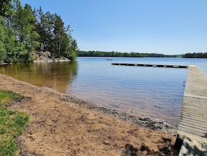A calm lake with a wooden dock extending into the water, surrounded by dense trees. - 4 Person Holiday Home in Vetlanda (Vetlanda)