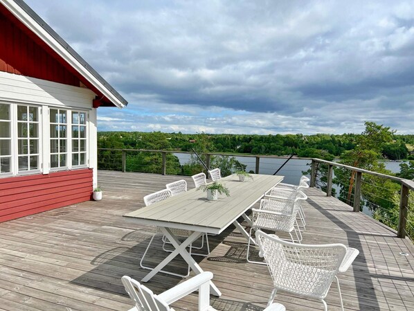 Enjoy meals on the outdoor dining area with a view of the water and surrounding forest.