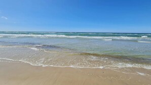 A beach with clear blue water and a sandy shore. - 2 Person Holiday Home in Brovst (Brovst)