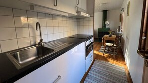 A modern kitchen with white cabinets, a black countertop, and a stainless steel sink. - 4 Person Holiday Home in Hillerstorp-by Traum (Hillerstorp)