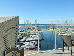 Uma marina com barcos atracados, céu limpo e vista para a água.