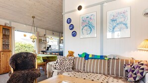 A cozy living room with a wooden table, a striped sofa, and a plush armchair. - 6 Person Holiday Home in Karrebaeksminde-by Traum (Karrebæksminde)