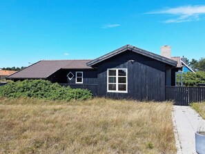 A single-story building with a dark exterior, a visible window, and a small porch area. - 4 Person Holiday Home in Skagen (Skagen)