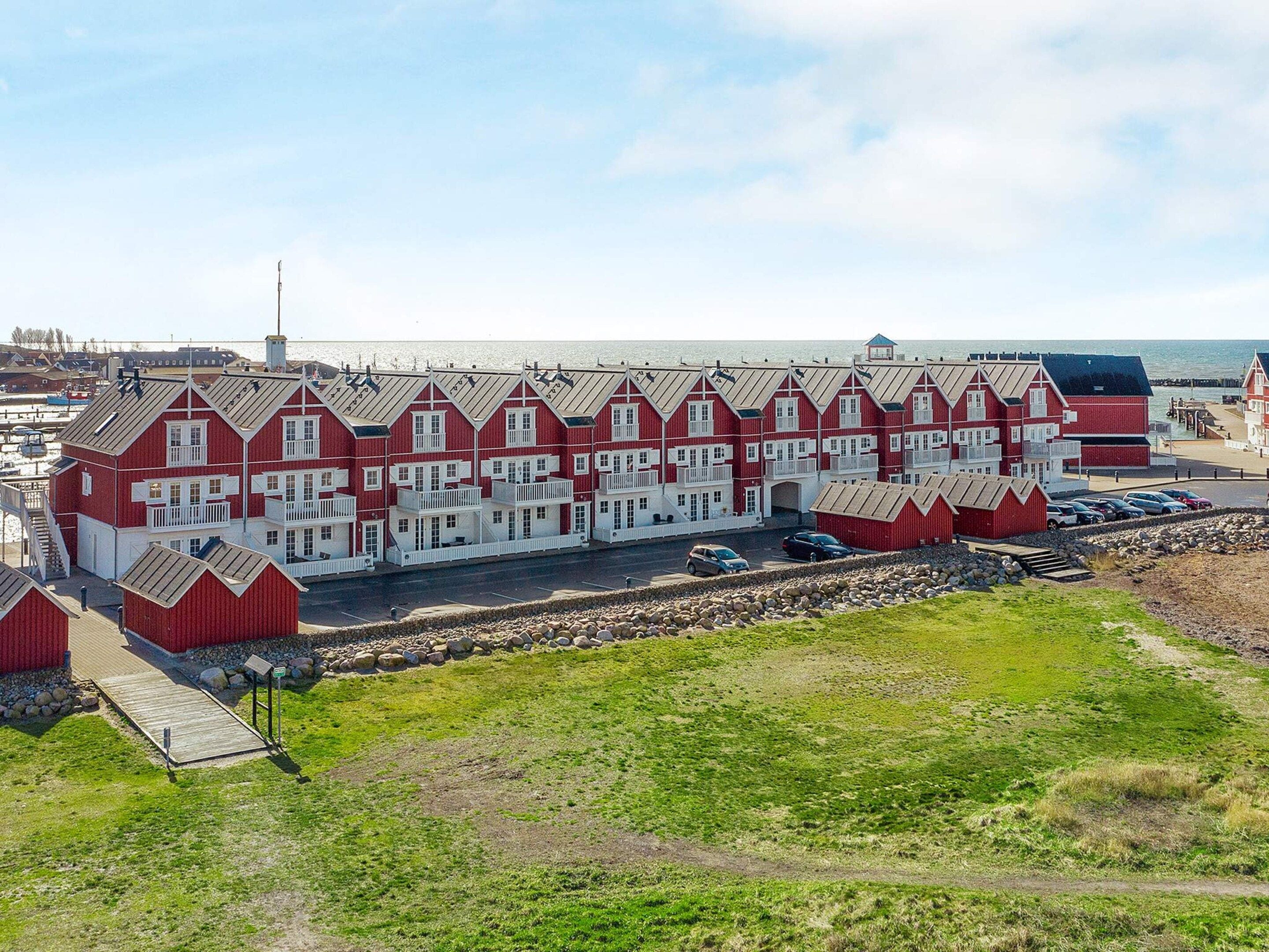 Une rangée de bâtiments rouges et blancs, avec un quai, qui semble être un hôtel ou un complexe touristique.