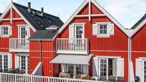 A red building with white trim, multiple windows, and balconies. - 5 Star Holiday Home in Bagenkop (Sydlangeland)