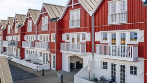 Une rangée de bâtiments rouges avec des balcons et des fenêtres blancs.
