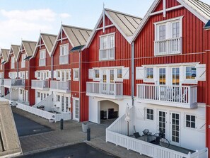 Une rangée de bâtiments rouges avec des balcons et des fenêtres blancs.