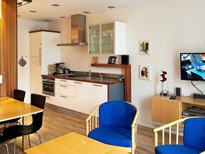 A modern kitchen with white cabinets, a stainless steel range, and a built-in oven.