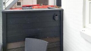 Et hjørne af et rum med en mørk trævæg, en ståldør og en lille stol.