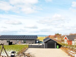 A modern building with a flat roof, a garage, and a paved driveway. - 4 Star Holiday Home in Vinderup (Vinderup)