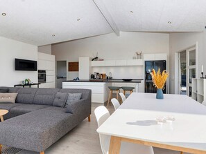 A modern kitchen with white cabinets, a black countertop, and a built-in oven. - 4 Star Holiday Home in Vinderup (Vinderup)