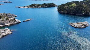 Un paisaje costero con aguas azul turquesa, afloramientos rocosos y abundante vegetación.