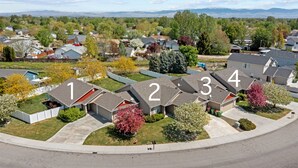 A residential area with numbered houses, green lawns, and trees. - 4 Adjacent Homes | Great for Families | Sleeps 32! (Meridian)