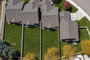 Vista aérea de una zona residencial con varias casas, un césped cuidado y una entrada de acceso curva.