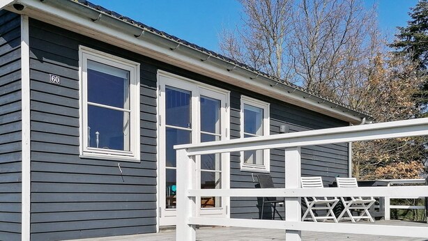 A two-story house with a covered porch and a staircase leading to the entrance. - 5 Person Holiday Home (Vordingborg)