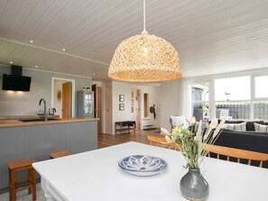 Enjoy meals in the central dining area with a white table and bench, illuminated by a unique pendant light.