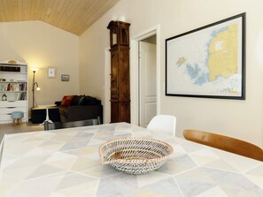 A room with a bed, a wooden cabinet, a map on the wall, and a bookshelf. - 6 Person Holiday Home in Nysted (Nysted)