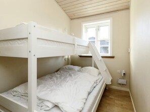 A bunk bed room with a window and a power outlet on the wall. - 6 Person Holiday Home in Nysted (Nysted)