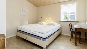 A bedroom with a bed, a desk, a chair, a window, and a ceiling light. - 6 Person Holiday Home in Nysted (Nysted)