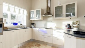 A modern kitchen with white cabinets, a black countertop, and a window providing natural light. - 6 Person Holiday Home in Nysted (Nysted)