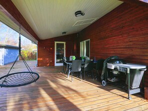 A covered patio with a hanging swing, outdoor seating, and a grill. - 6 Person Holiday Home in Nysted (Nysted)
