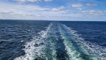 Vista del océano con estela detrás de una embarcación en movimiento.