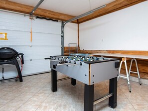 Ein Zimmer mit einem Kicker, einem Stuhl und einer Leiter.