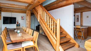 A wooden interior with a dining area, staircase, and kitchen.