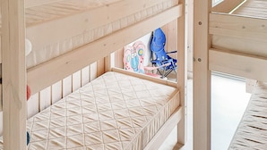 Una cama litera con un colchón acolchado y un juguete en la cama inferior.