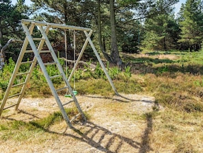 Relax in a serene natural setting with a charming swing set amidst lush greenery.