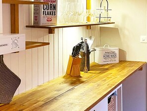 Un comptoir de cuisine avec une boîte de céréales, un porte-verres à vin et un récipient portant l'inscription « Fait maison ».