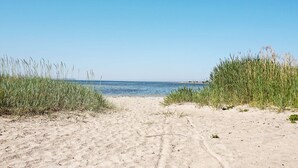 A sandy beach with tall grass on either side leading to the sea. - 4 Star Holiday Home in Gotlands Tofta (Gotlands Tofta)