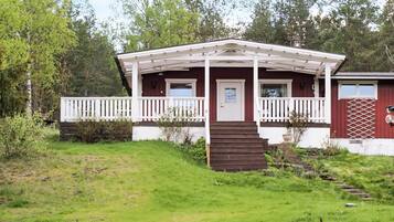 A single-story building with a porch, a door, and a small set of stairs leading to the entrance.