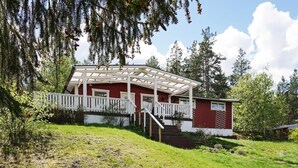 A red cabin with a white porch and stairs leading to a door. - 5 Person Holiday Home in Strangnas (Strängnäs)