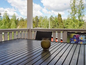 A wooden deck with a table and a decorative vase, overlooking a forested area. - 5 Person Holiday Home in Strangnas (Strängnäs)