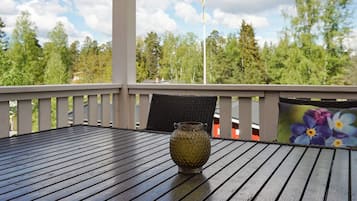 A wooden deck with a table and a decorative vase.