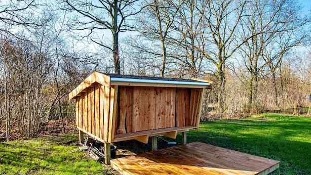 A wooden structure with a flat roof, elevated on stilts, and a wooden platform in front. - 5 Star Holiday Home in Ansager (Ansager)