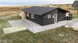 A modern black building with a flat roof, a small porch, and a view of the beach. - 6 Person Holiday Home in Laeso-by Traum (Læsø)